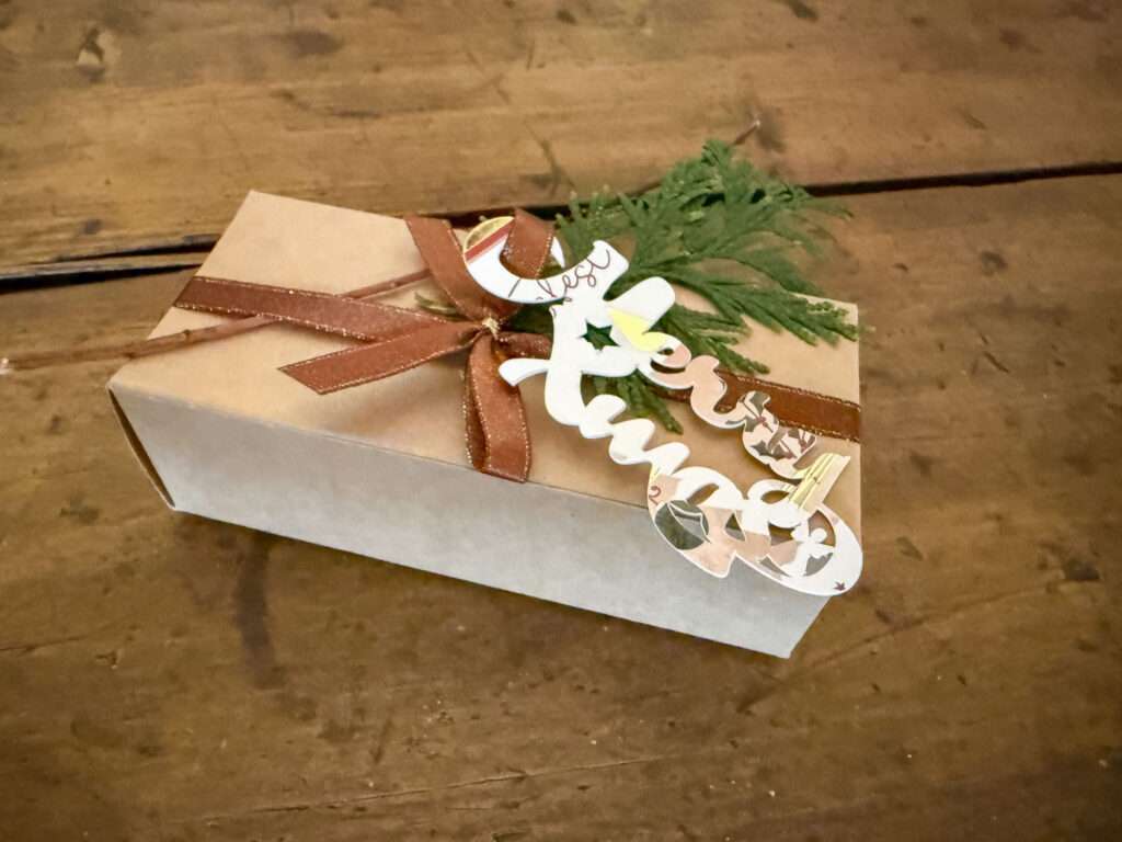 „Merry-Xmas“-Schriftzug + Päckchen = kleinem Statement für Nachhaltigkeit und Kreativität.