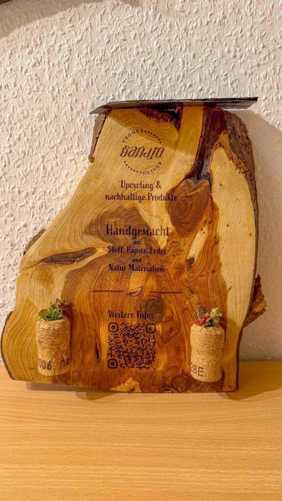 Ein Holzquerschnitt aus dem Vorrat, zwei ausgebohrte Sektkorken und Dachwurzel als lebende Deko.